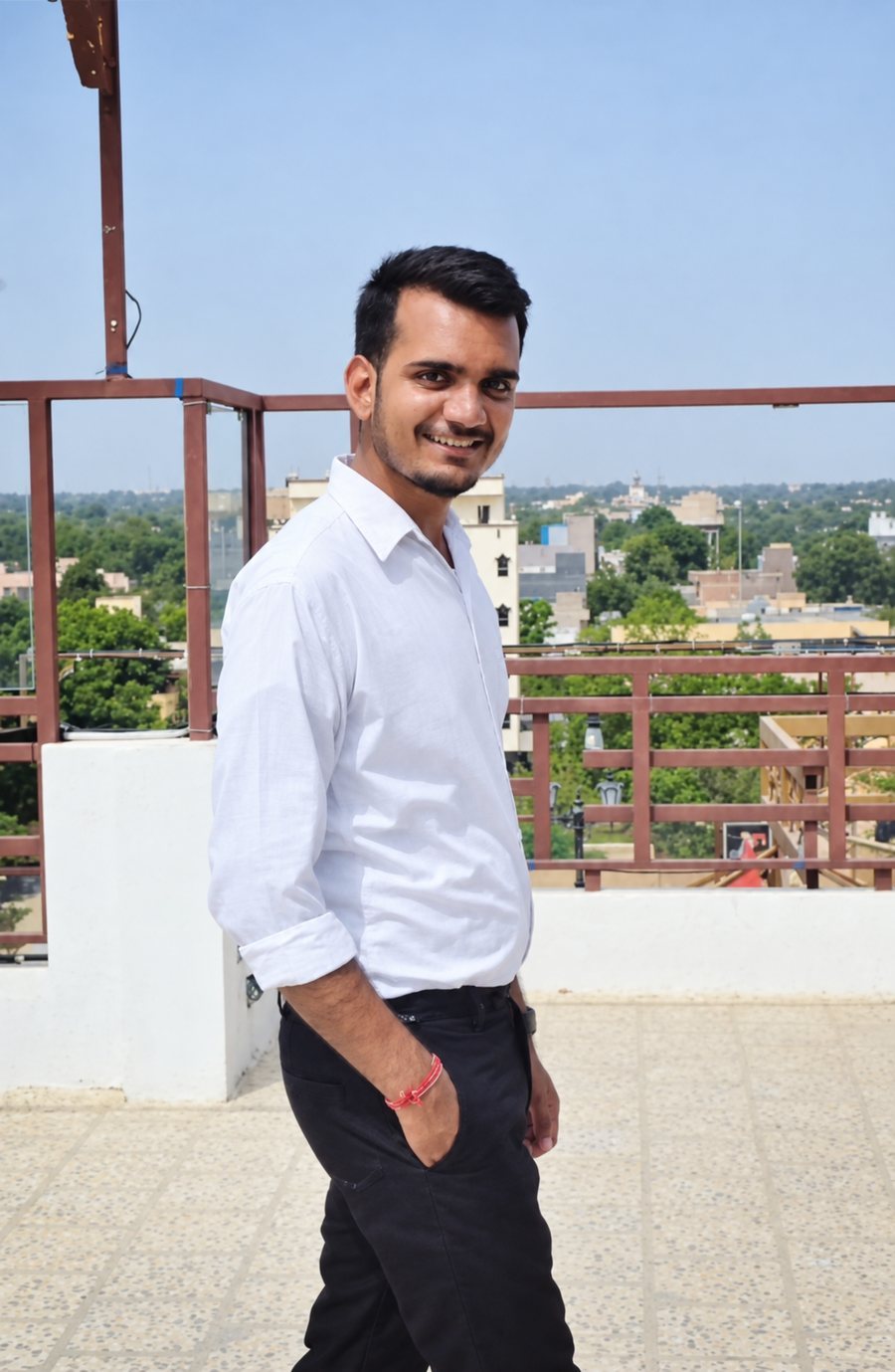 Neeraj Yadav standing on a rooftop, wearing a white shirt